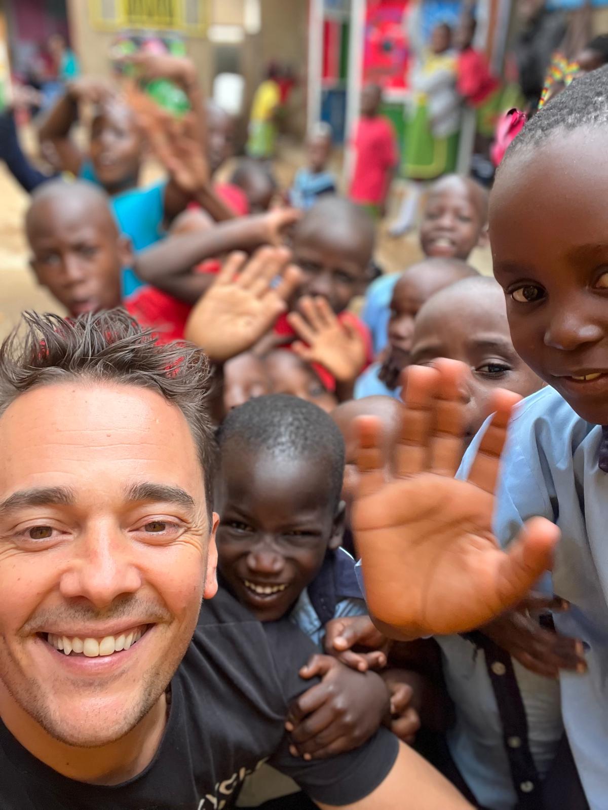 Álex rodeado de niños sonrientes