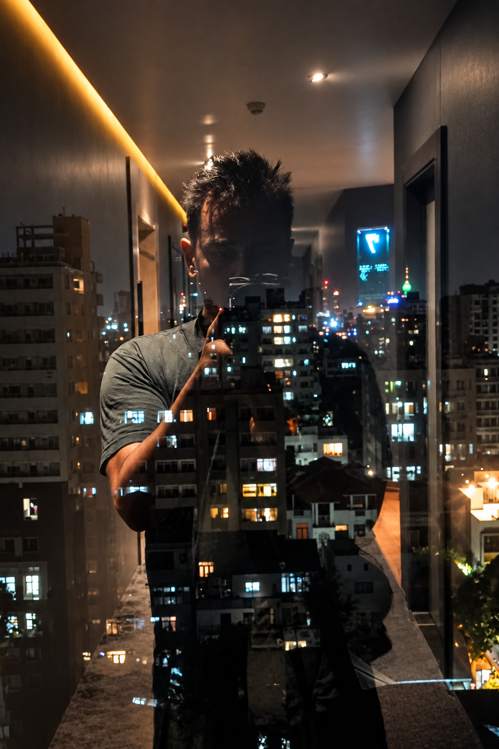 Álex fotografiando la ciudad de noche tras un cristal
