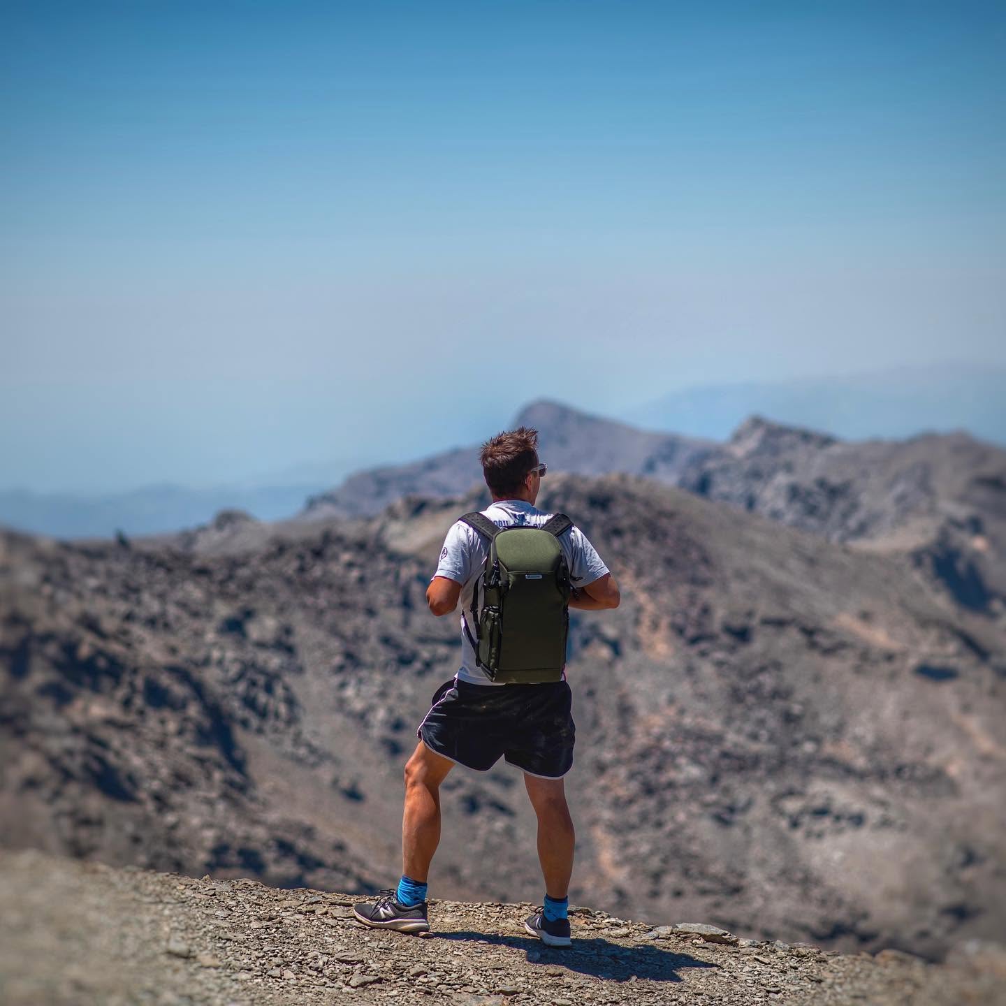 Álex de espaldas en la cumbre, mirando la sierra